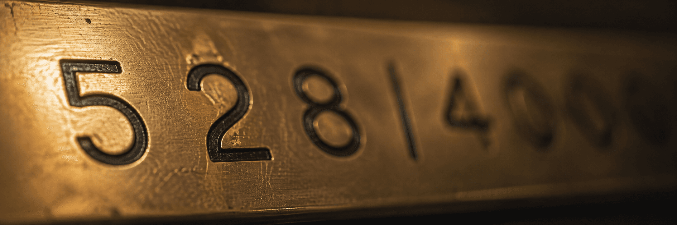 Macro photograph of engraved numerals on a brass telephone exchange plate.